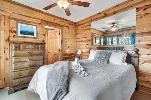 Un dormitorio con una cama y un ventilador de techo. en Alpine Splendor Family Game Room Views Hot Tub, en Sevierville
