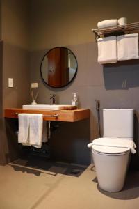 a bathroom with a toilet and a sink and a mirror at Cala Laiya in San Juan