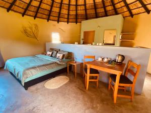 um quarto com uma cama, uma mesa e cadeiras em Izulu Eco Lodge em Sodwana Bay