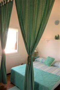 カンニジョネにあるResidenza Mediterraneaのベッドルーム1室(緑のカーテン付きのベッド2台付)