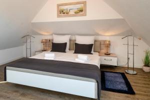 ツィングストにあるTraumzeit, FW 1のベッドルーム(白い大型ベッド、ランプ2つ付)