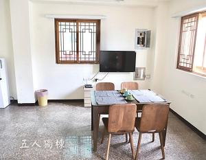 um quarto com uma mesa e cadeiras e uma televisão em 沐光獨棟館 em Nangan