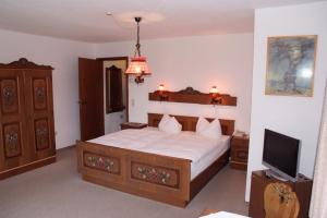 ein Schlafzimmer mit einem großen Bett und einem TV in der Unterkunft Hotel Schwalenberger Malkasten in Schieder-Schwalenberg