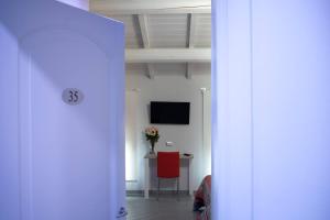 corridoio con camera con tavolo e TV di Agriturismo La Sapienza a Monestirolo