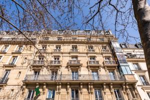 a large building with a balcony on the side of it at Tourville - Très beau studio - Bail mobilité in Paris
