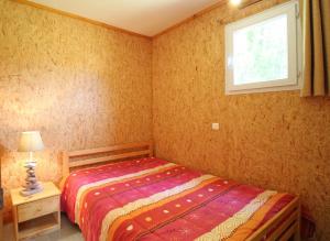 een kleine slaapkamer met een bed en een raam bij Le mas - gite n°5 in Vaulry