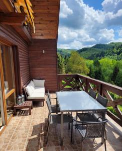 a patio with a table and chairs on a deck at Chatka Beskidzka in Targanice