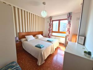 a bedroom with two beds and a window at Espacioso apartamento con impresionantes vistas y garaje privado - Dos Torres Tauriel in Zaragoza