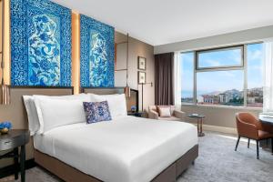 فندق The Ritz-Carlton, Istanbul at the Bosphorus في إسطنبول: غرفة فندقية بسرير ونافذة كبيرة