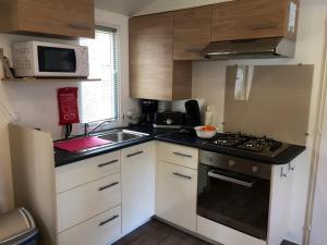 Kuchyňa alebo kuchynka v ubytovaní Bungalow convivial à Saint-Brevin-les-Pins avec piscine - 32 m²