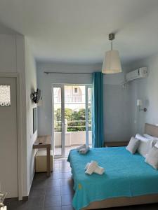 Kimiro Drosia Zante في Psarou: غرفة نوم بسرير ازرق عليها مناشف