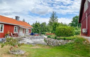 een huis met een stenen muur naast een rood gebouw bij Beautiful Home In Vstervik With Wifi in Västervik