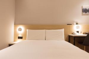 Giường trong phòng chung tại 旅居文旅板橋驛站-湳雅夜市館Hub Hotel Banqiao inn-Nanya Night Market Branch