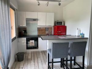 uma cozinha com um balcão e um frigorífico vermelho em Chez Mel et Manu em Sanary-sur-Mer