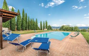 a swimming pool with blue chairs and a table at Seranna 4 in Papiano