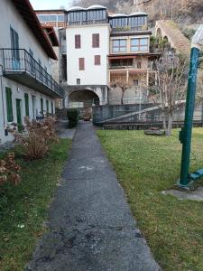 a walkway in front of a building and a house at Patty ZU - Lakeside apartment in Riva di Solto