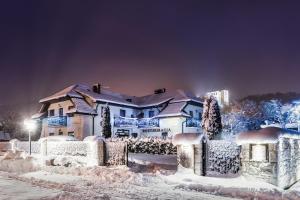 una casa cubierta de nieve por la noche en Austeria Kazimierska, en Kazimierz Dolny
