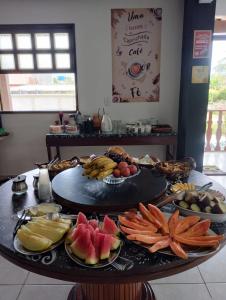 un tavolo con un mucchio di frutta e verdura sopra di POUSADA ARKAN BEACH a Saquarema
