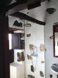 una doccia in bagno con rocce sul muro di Joya del Jable a Tao