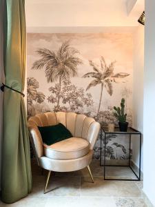 a living room with a chair and a wall mural at Villa Pruly Hotel Cannes Centre in Cannes +16 photos
