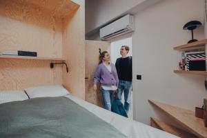 Un uomo e una donna sono in piedi in una camera da letto di Cabane Urbaine 3 - centre a Namur