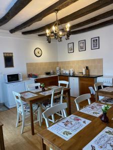 Fleur de Lys في Ansac-sur-Vienne: مطبخ وغرفة طعام مع طاولات وكراسي خشبية