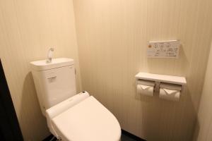 a bathroom with a white toilet and two rolls of toilet paper at HOTEL LiVEMAX Nihonbashi Hakozaki in Tokyo