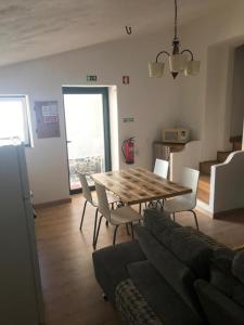 a living room with a wooden table and chairs at Casinha da Estrela in Arraiolos +10 photos