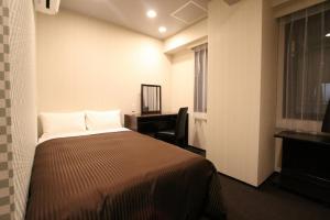 a bedroom with a bed and a desk and a window at HOTEL LiVEMAX Nihonbashi Hakozaki in Tokyo