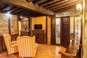 帕薩若的住宿－La casa del Rollo，客厅配有两把椅子和电视