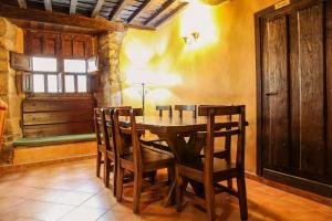a dining room with a wooden table and chairs at La casa del Rollo in Pasarón