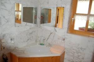 ein weißes Badezimmer mit einem Waschbecken und einem Spiegel in der Unterkunft Ferienwohnungen Haus Reineck in Bayerisch Eisenstein