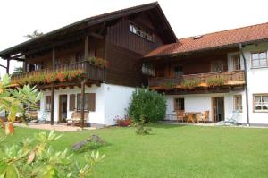 ein großes Holzhaus mit Rasen davor in der Unterkunft Ferienwohnungen Haus Reineck in Bayerisch Eisenstein