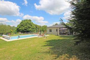 un patio con piscina y una casa en Les cypres, en Magnac-Bourg