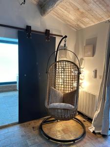 a room with a hanging chair in front of a door at La chambre de Léopoldine in Vérargues +1 photo