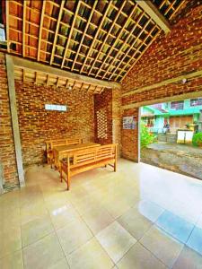 a room with two wooden benches and a brick wall at Homestay Bukit Dagi Borobudur in Borobudur