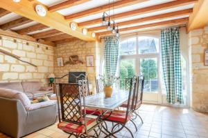ein Wohnzimmer mit einem Tisch und einem Sofa in der Unterkunft Maison Meslaie - Maison pour 8 avec piscine in Beaumont-en-Véron