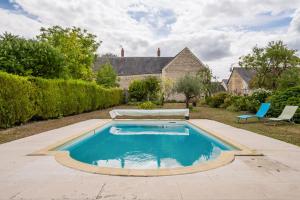 a swimming pool in the yard of a house at Maison Meslaie - Maison pour 8 avec piscine in Beaumont-en-Véron