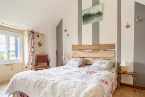 a bedroom with a large bed with a wooden headboard at Maison Meslaie - Maison pour 8 avec piscine in Beaumont-en-Véron +9 photos