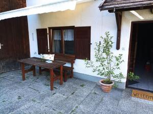 un banco de madera sentado frente a una casa en Ferienhaus am Tal des Lebens, en Utting am Ammersee
