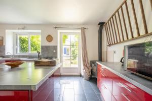 a kitchen with a counter and a tv in it at Maison Meslaie - Maison pour 8 avec piscine in Beaumont-en-Véron