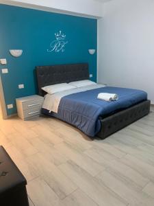 1 dormitorio con 1 cama grande y pared azul en New zarà, en Villa San Giovanni