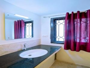 a bathroom with a sink and a mirror at IVY RESIDENCY in Coimbatore