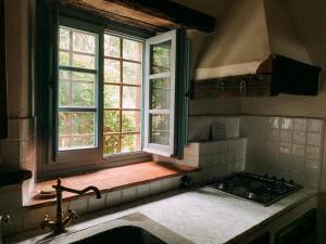 een keuken met een raam, een wastafel en een fornuis bij Casale gli ulivi in Donnini