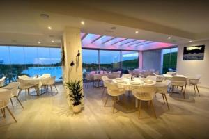 a restaurant with white tables and chairs and windows at Al-1103 Estepona - Apartment - Alcazaba Lagoon in Estepona