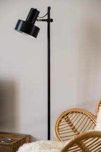 una lámpara negra junto a una mesa y una silla en Hoeve de Binnenplaets Schimmert, en Schimmert