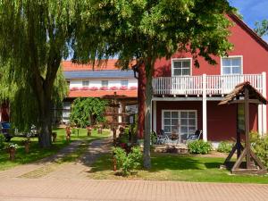 a red house with a playground in front of it at Pension Auf der Tenne in Klöden