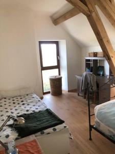 a attic room with a bed and a window at La Masure in Les Rameaux