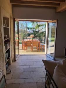 an open door to a patio with a table and chairs at La Masure in Les Rameaux