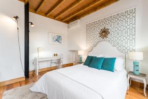 ein Schlafzimmer mit einem großen weißen Bett mit blauen Kissen in der Unterkunft R3 Service - Five Senses in Coimbra in Coimbra